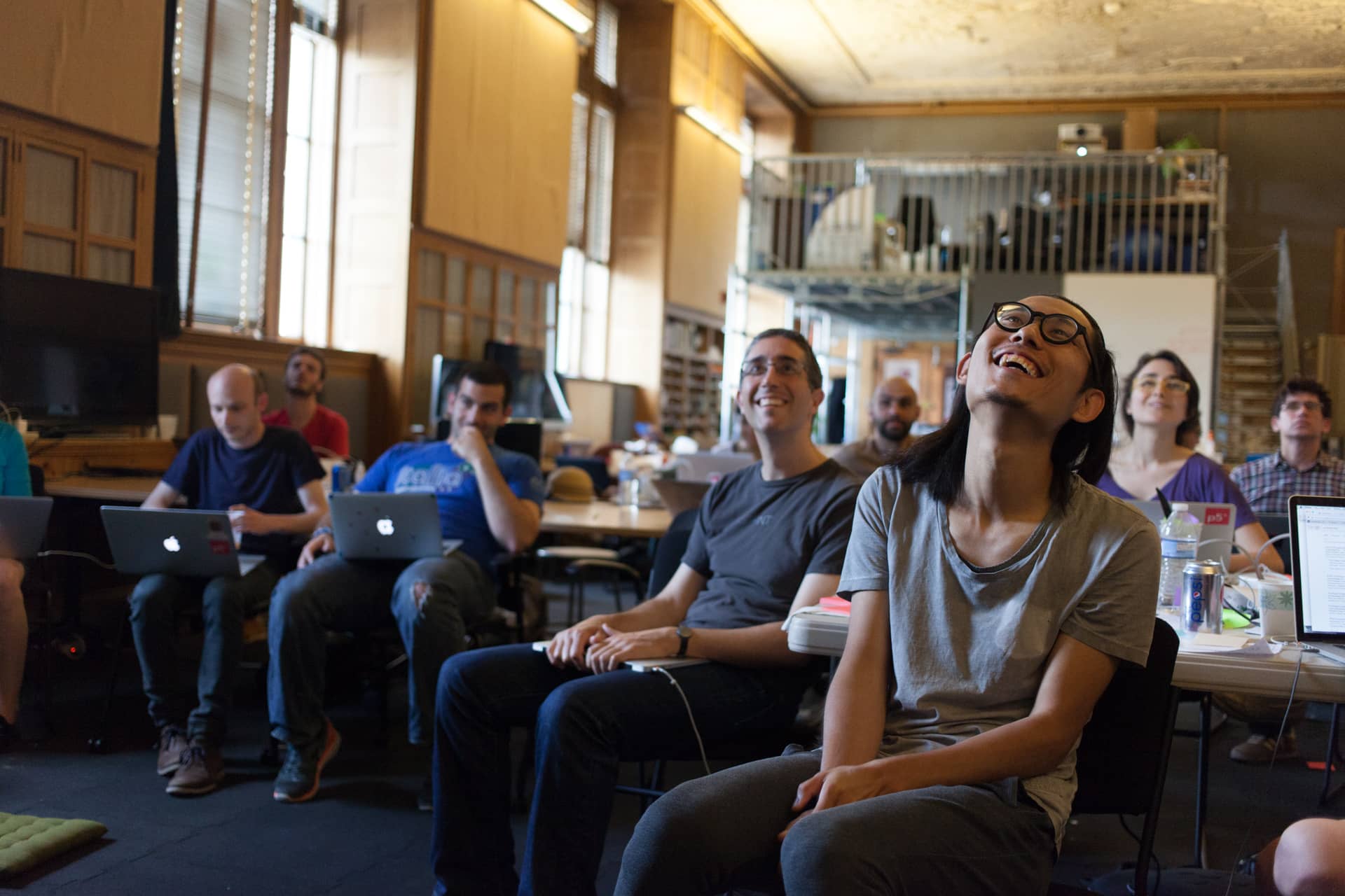 Participants attentively smile and listen to a presentation"