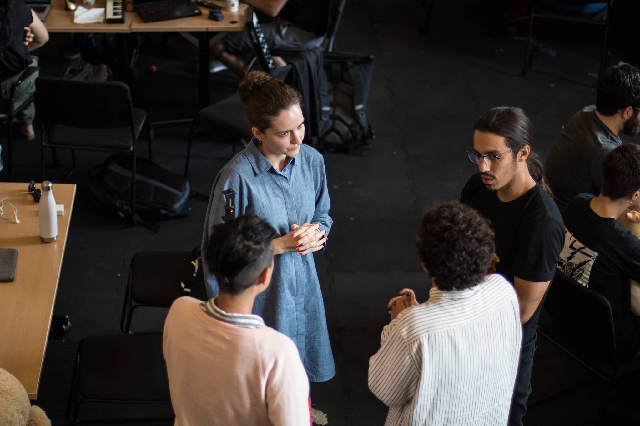 Four participants standing in a circle conversing"